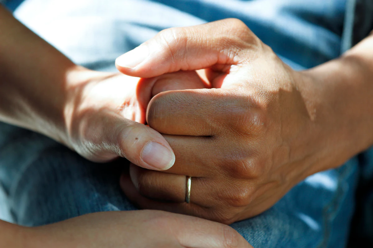 A caregiver holding a patient's hand